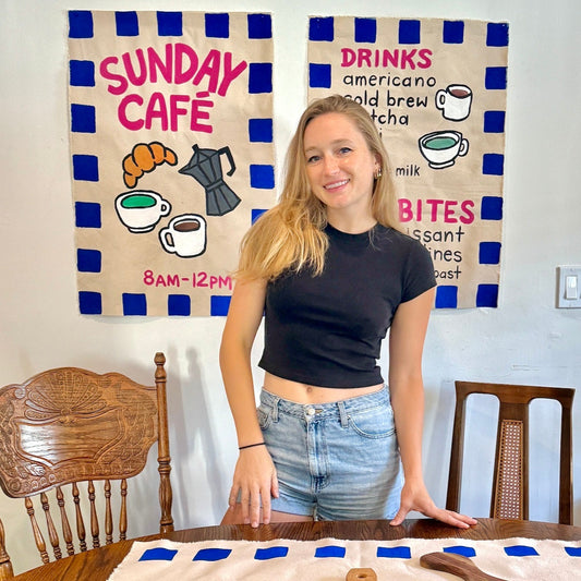 Painted banner with coffee shop motifs and young girl crafting it