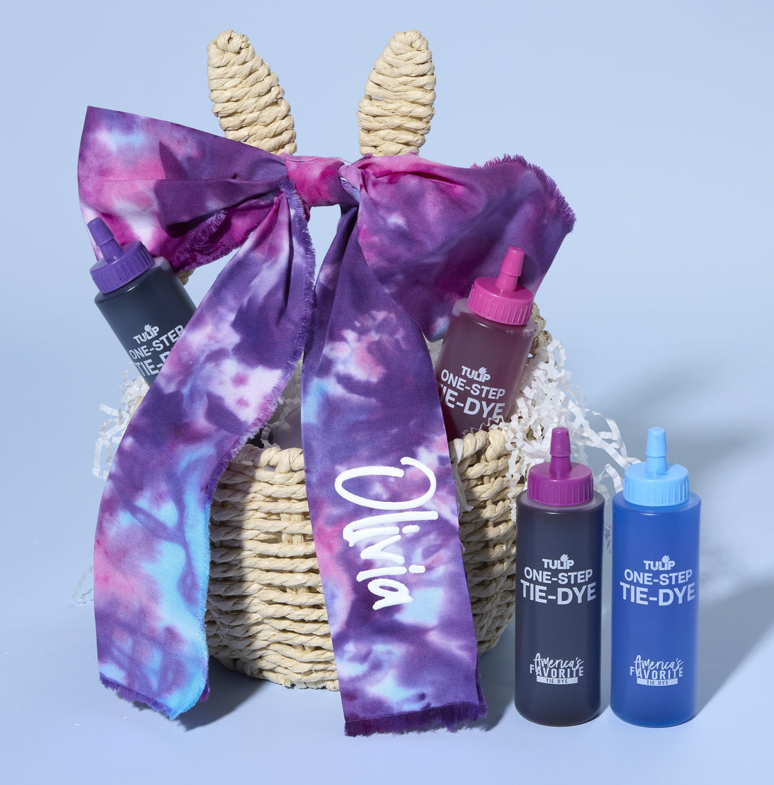 Bunny Easter basket with big tie dye purple bow with the name Olivia on the right tail. Two bottles of Tulip tie dye to the right