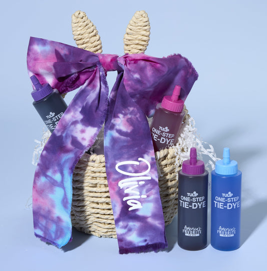 Bunny Easter basket with big tie dye purple bow with the name Olivia on the right tail. Two bottles of Tulip tie dye to the right