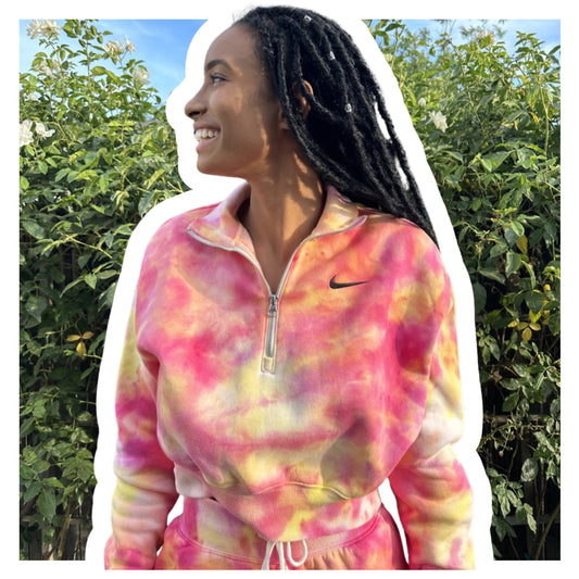 Girl wearing a Nike tie dye outfit with plants on the background 