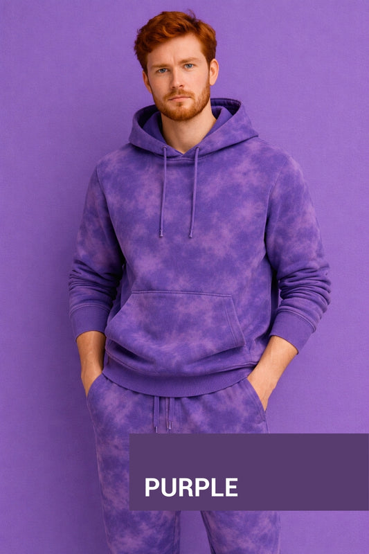 Man wearing a purple tie-dye hoodie and pants against a purple background