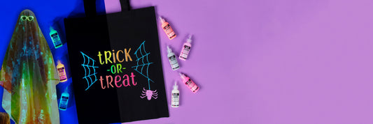Halloween-themed product display with 'Trick or Treat' bag and small bottles on a purple background